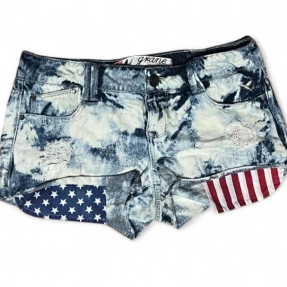 “Grane” acid washed low rise shorts w American flag print statement pockets.